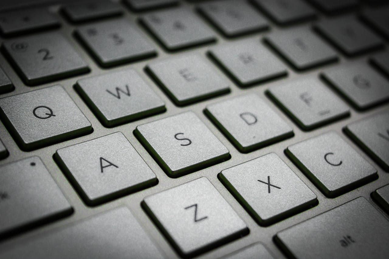 A detailed macro shot of a sleek modern computer keyboard featuring the QWERTY layout.
